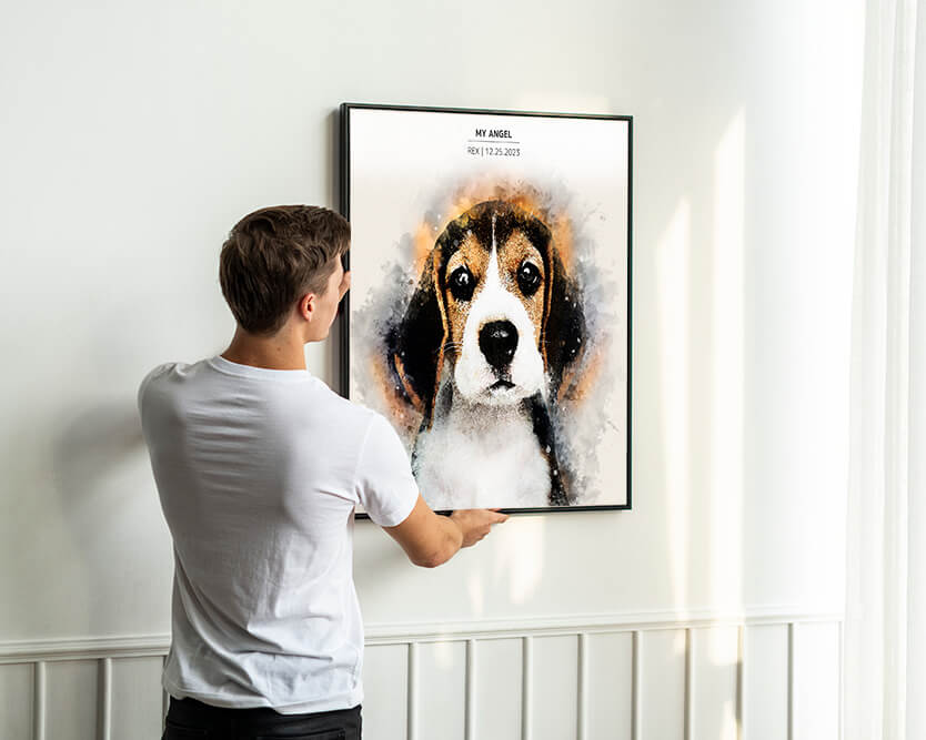 A man hanging a frame of a custom dog portrait