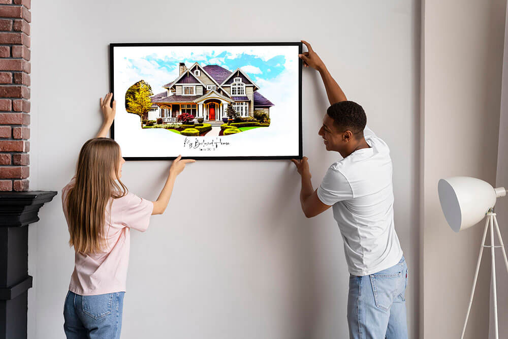 Couple hanging a frame of house portrait