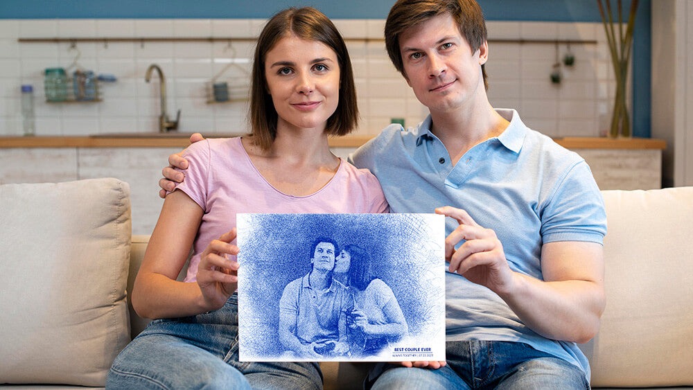 Couple on a sofa holding a frame of them